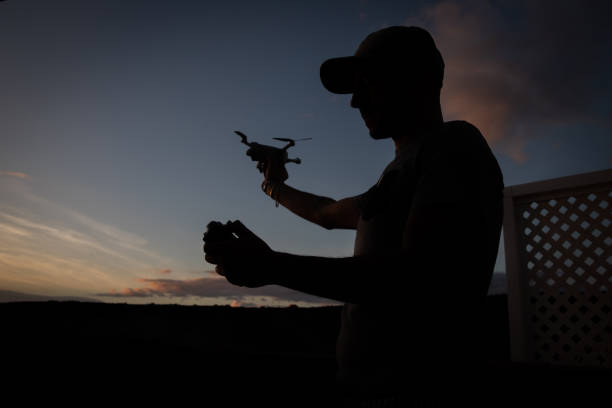 istock Silhouette of a drone pilot about to fly his drone during sunset. 1446371552