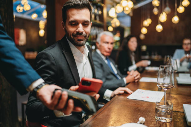 istock A man is paying the bill at the restaurant using his smart phone 1446375106