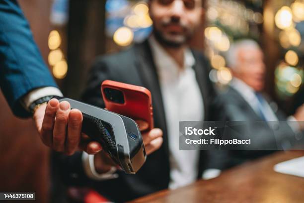 A Man Is Paying The Bill At The Restaurant Using His Smart Phone Stock Photo - Download Image Now