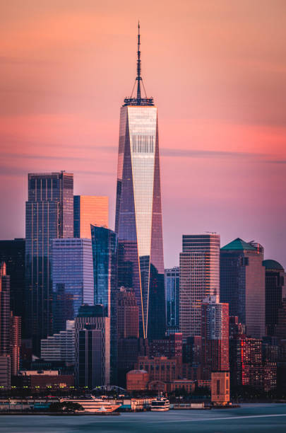 Lower Manhattan and the Freedom Tower under a colorful sunset in summer.