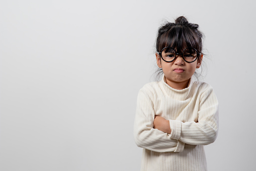 Angry little girl over white background, sign and gesture concept