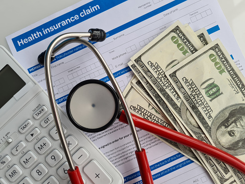 Medical reimbursement with health insurance claim form and stethoscope with money dollars. Health care and modern medicine concept