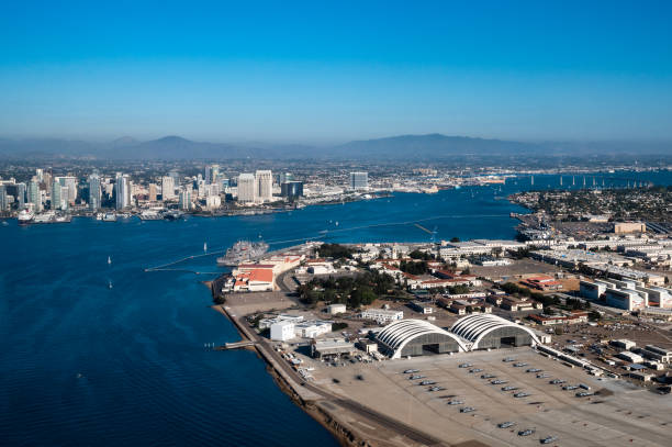 vista aérea de la base aérea naval de la isla norte en coronado y el centro de san diego, california, mientras vuela sobre la bahía con botes en el agua y montañas en el fondo durante el día - day san diego california harbor downtown district fotografías e imágenes de stock