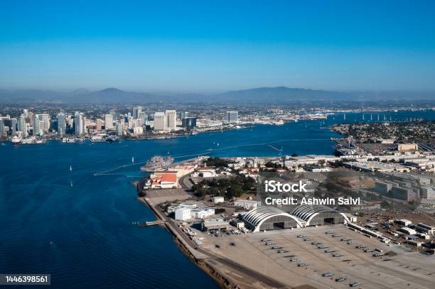 Aerial View Of North Island Naval Air Base On Coronado And Downtown San Diego California While Flying Over The Bay With Boats On The Water And Mountains In The Background During Daylight Stock Photo - Download Image Now