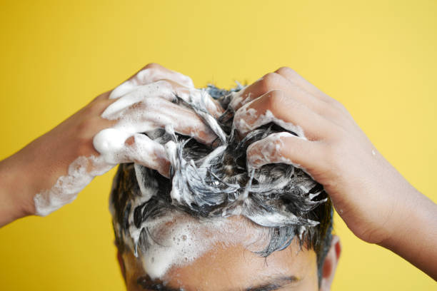 istock young men washes h his hair with shampoo . 1446403046
