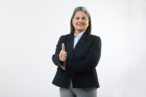 Portrait of confident Indian mature businesswoman wearing formalwear giving thumbs up