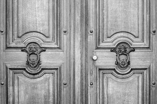The antique gray wooden doors with metal clappers