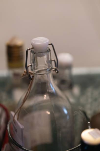 istock Vertical shot of an empty glass bottle with a plastic lid in a blurred background 1446407760