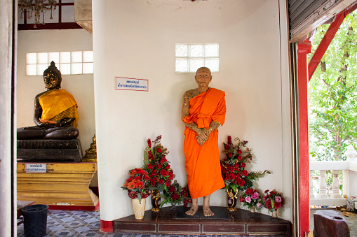 Vientiane, Vientiane, Laos- September 1, 2018: Two young orange robed Buddhist monks sitting in a small temple in Vientiane, Laos.