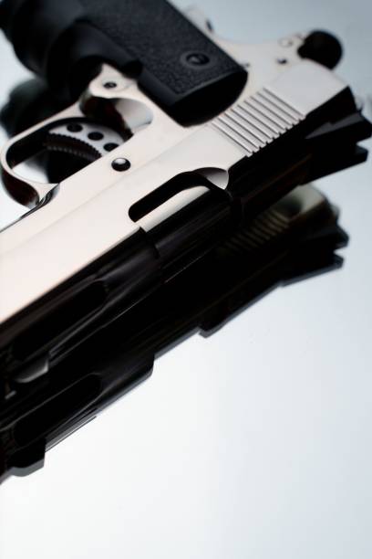 istock Vertical closeup of an isolated silver compact handgun on a white background 1446408321