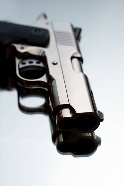istock Vertical closeup of an isolated silver compact handgun on a white background 1446408324