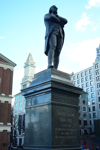 A low-angle shot of the Samuel Adams Statue against a blue sky