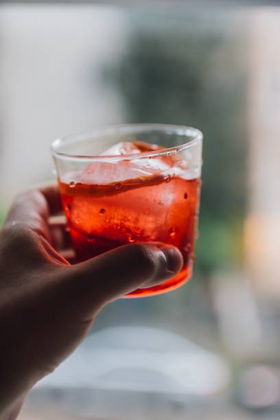 istock hand holding up red Negroni cocktail 1446411028
