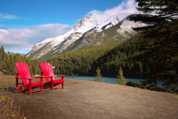 istock Red wooden chairs on the lakeside with densely forested hills background 1446412595
