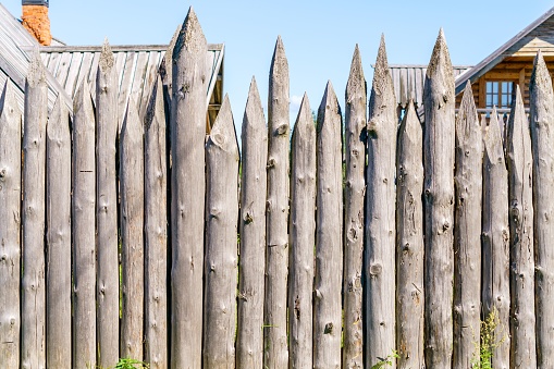 A wooden fence made of logs on a sunny day