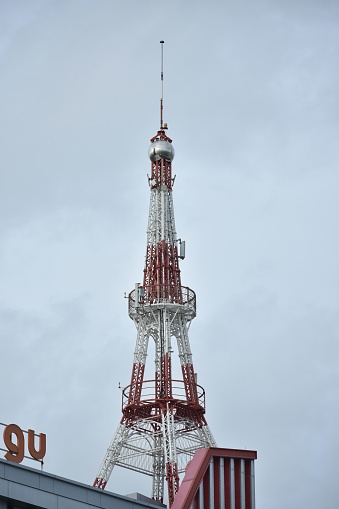 A vertical shot of a telecommunications tower against a blue sky