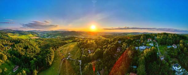 istock Panoramic view of a sunset over the woods and a small town. 1446414130