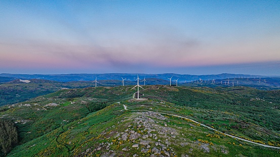 An aerial shot of wind turbines with a green landscape