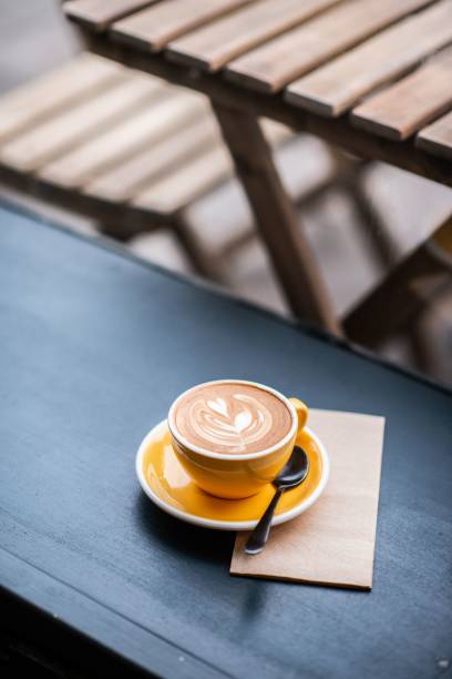 istock Vertical shot of cappuccino in a yellow coffee cup on the table 1446419947