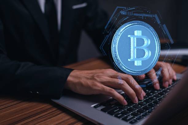 istock Man using a laptop with a crypto currency coins Bitcoin on the screen 1446420113