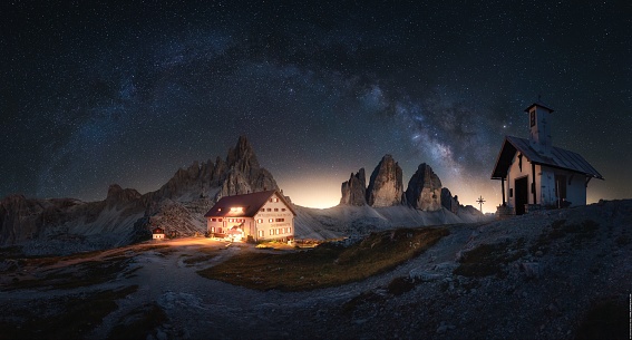 A beautiful view of a house with Trecime di lavadero under a sky with milky way in Italy