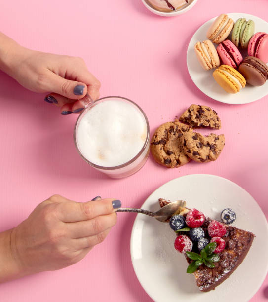 istock Table with various cookies, donuts, cakes, coffee cups on pink background. 1446422057