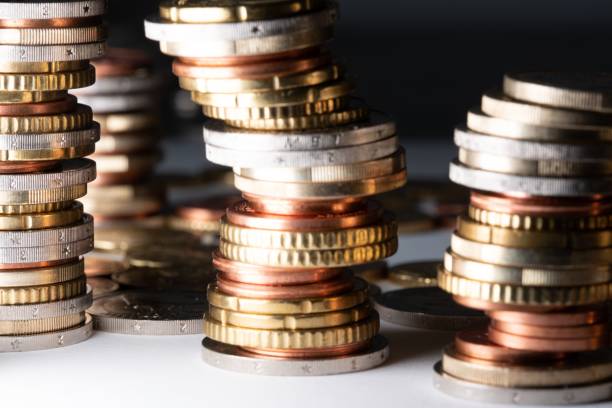 istock Closeup shot of different Euro coins piled and stacked on a white surface 1446422864