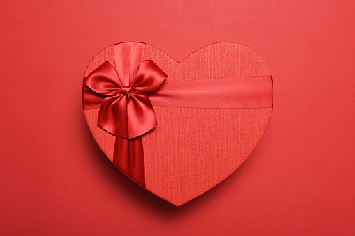 Directly above a red heart shape gift box on the red background