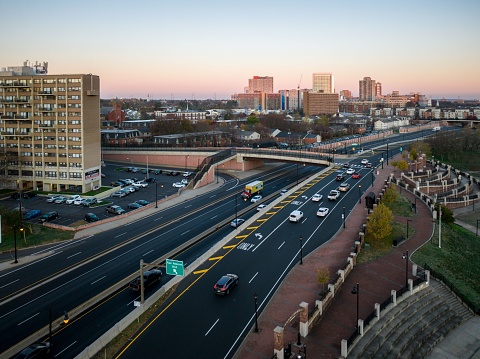 A drone view of a city skyline with highways and buildings at sunrise in New Brunswick, Rutgers. Hub City, USA