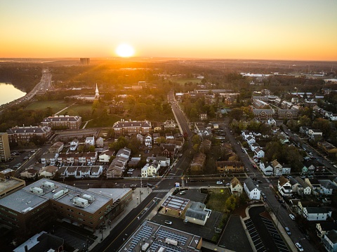 A drone view of a city skyline with buildings near the river at sunrise in New Brunswick, Rutgers, Hub City, USA