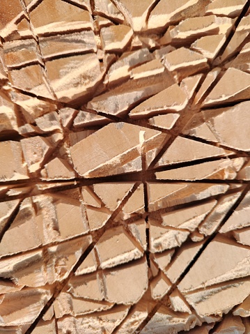 A vertical shot of an abstract textured background in nude color with many cracks