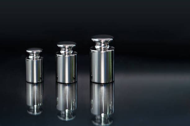 Close-up of weights used for scale calibration on a black background.