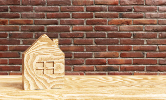 Real estate concepts. A wooden house on the wood with brick wall backgrounds