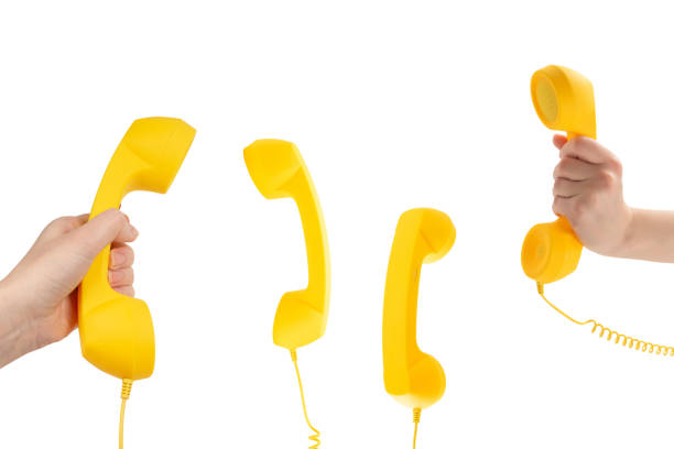 Yellow handset in woman hand isolated on white. Copy space.