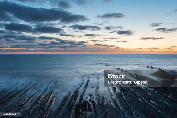 Beautiful Sunset Landscape Image Of Welcome Mouth Beach In Devon England With Beautiful Rock Formations Stock Photo - Download Image Now