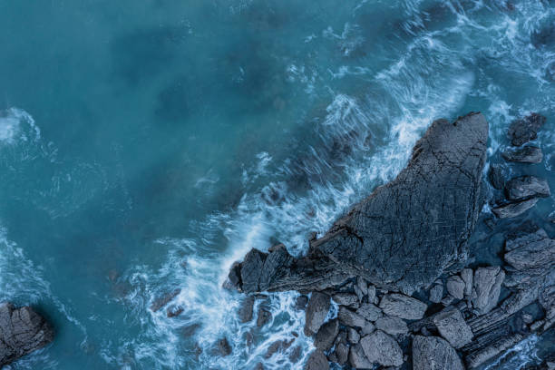 luft-drohnenlandschaft vogelperspektive des pulsierenden sonnenuntergangs über dem welcombe mouth beach in devon england mit wellen, die auf felsen stürzen - tide aerial view wave uk stock-fotos und bilder