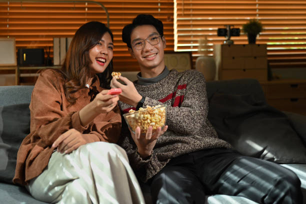 istock Couple watching moving, television streaming services while sitting on a Couch in the living room. 1446438550
