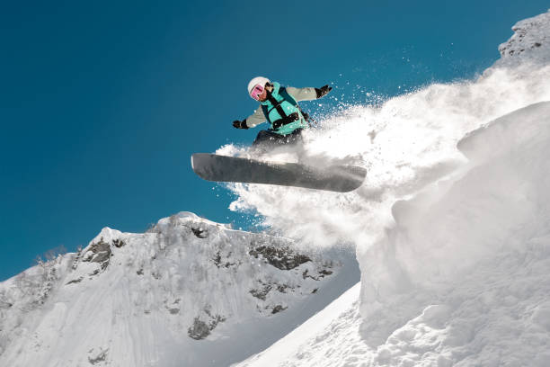 girl snowboarder jumps on snowboard in mountains - ski jumping snowboarding snowboard jumping imagens e fotografias de stock