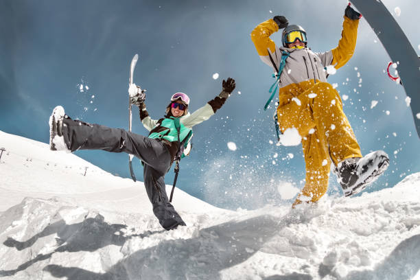 Happy couple snowboarders having fun Happy couple of snowboarders are having fun and jumps with snowboards in hands. Winter holidays at ski resort snowboard stock pictures, royalty-free photos & images