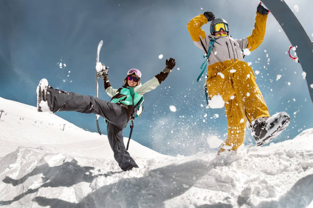 Happy couple snowboarders having fun Happy couple of snowboarders are having fun and jumps with snowboards in hands. Winter holidays at ski resort snowboarder stock pictures, royalty-free photos & images