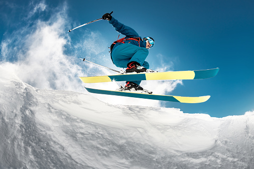 Close-up photo of skier jumping over camera
