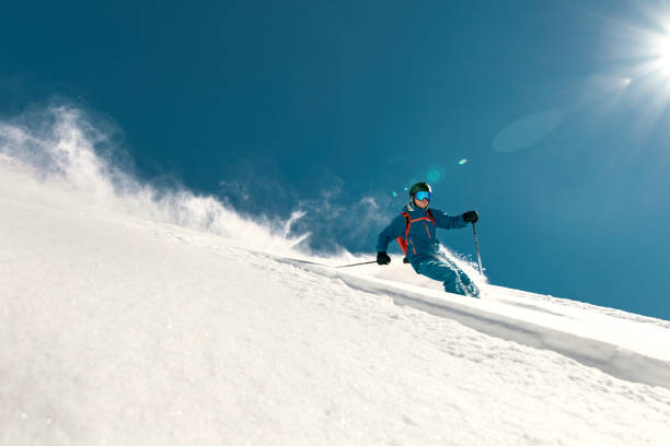 schnelle skifahrerfahrten über die skipiste - abfahrtslauf stock-fotos und bilder