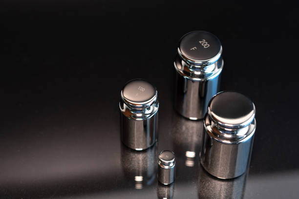 Close-up of weights used for scale calibration on a black background.