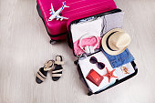 Suitcases with clothes, hat, passport and leisure accessories. Summer travel, preparation for the trip