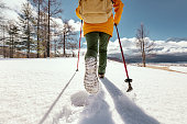 Close up photo of woman's legs walking in deep snow