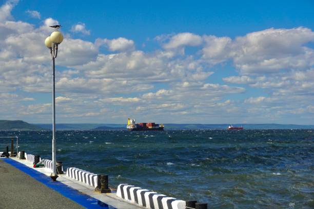 las olas rompen en un muelle en vladivostok. olas altas con salpicaduras golpean contra el muelle. clima soleado de verano en vladivostok. una tormenta en vladivostok. las olas de agua se elevan sobre el muelle. - water waterfall sky seascape fotografías e imágenes de stock