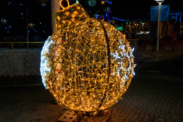 istock Large illuminated Christmas bauble on a city square 1446446366