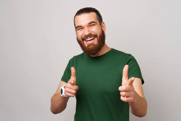 Handsome man is looking for you while pointing with two fingers at the camera. stock photo