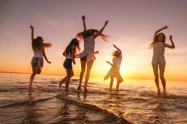 행복한 어린 소녀들이 일몰 바다 해변에서 춤을 춘다 - jumping freedom women beach 뉴스 사진 이미지