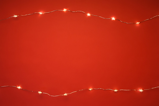Christmas lights on the red background with copy space